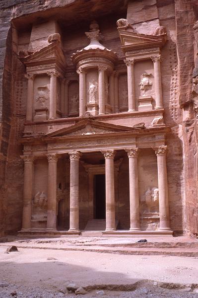 Jordan-12-Seib-1980.jpg - The siq opens up onto Petra’s most magnificent façade; in arabic  Al-Khazneh or the Treasury. It is almost 40 meters high and intricately decorated with Corinthian capitals, friezes, figures and more. The Treasury is crowned by a funerary urn, which according to local legend conceals a pharaoh’s treasure; the Treasury was probably constructed in the 1st century BC (photo by Roland Seib)