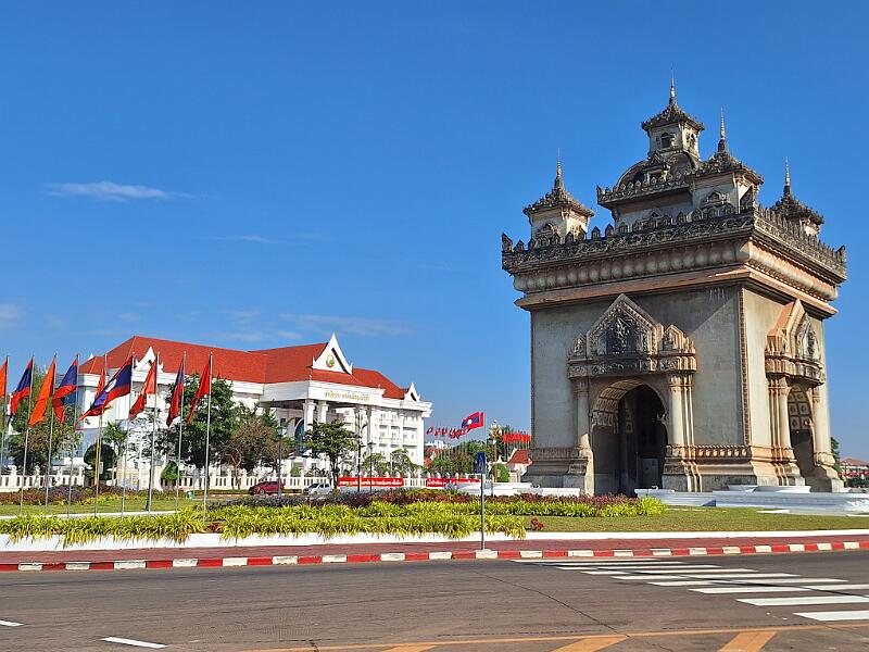 Laos1-14-Seib-2025.jpg - Patuxai Monument (meaning Victory Gate) was built to celebrate independence from France; initially called Anousavari (gift from friends); on the left Parliament (Photo by Roland Seib)
