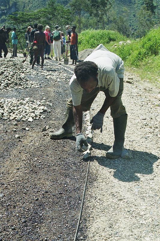 Papua1-54-Zoellner.jpg - Workers spread stones and gravel and mark the brim of the road, Wamena, Jayawijaya regency (2008)(Photo by Siegfried Zöllner)
