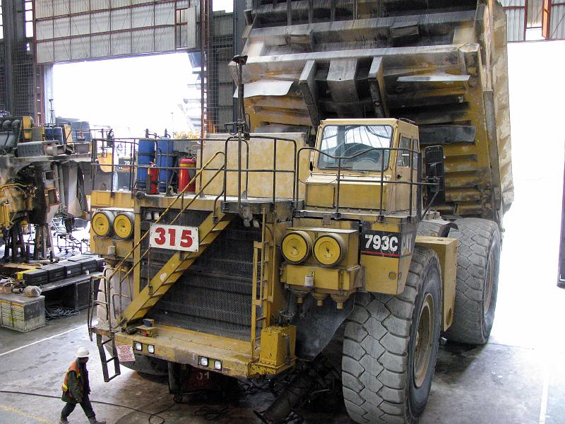 Papua2-09-Zoellner-2008.jpg - A  truck in the maintenance workshop. Caterpillar runs this workshop. Since is obliged by contract to supply 100 properly working trucks at all times, around 20 spare trucks are always waiting inside the workshop to replace broken ones (Photo by Siegfried Zöllner)